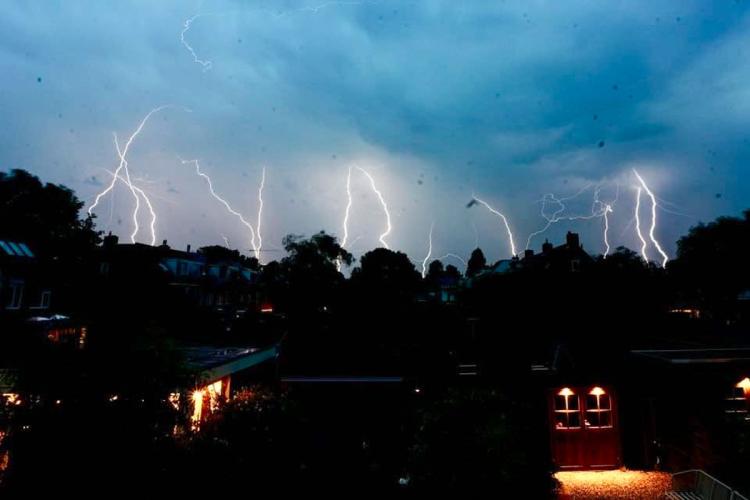 Onweersbuien kleuren de avondlucht boven Ambacht
